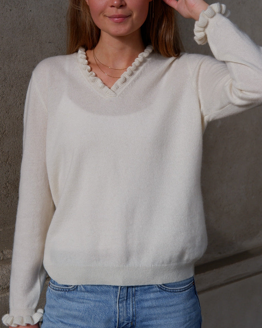 Kvinde iført cashmere bluse i med flæsedetaljer ved halsudskæring, Natural White.