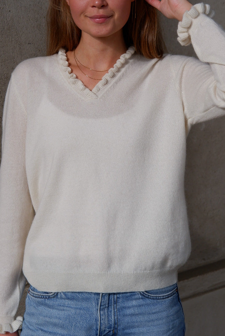 Kvinde iført cashmere bluse i med flæsedetaljer ved halsudskæring, Natural White.