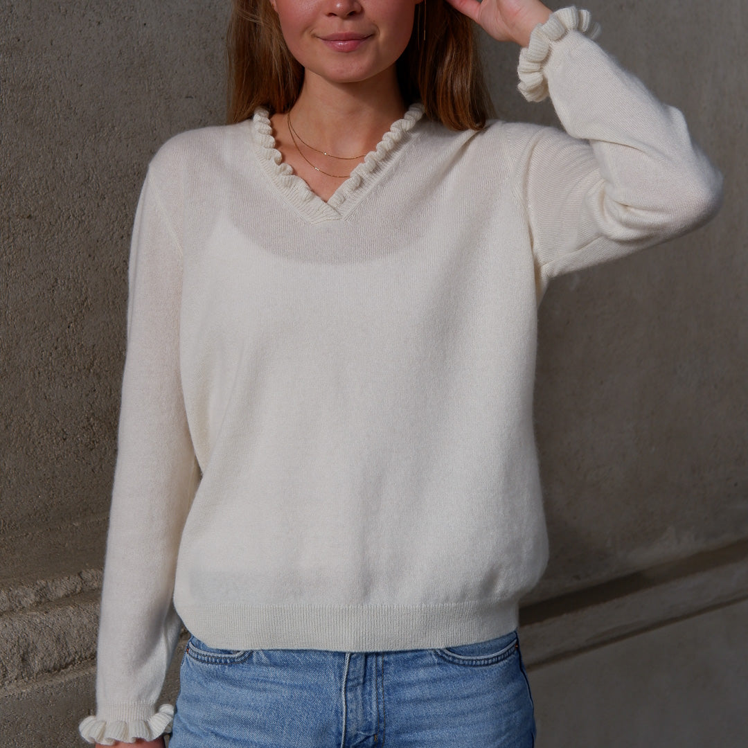 Kvinde iført cashmere bluse i med flæsedetaljer ved halsudskæring, Natural White.