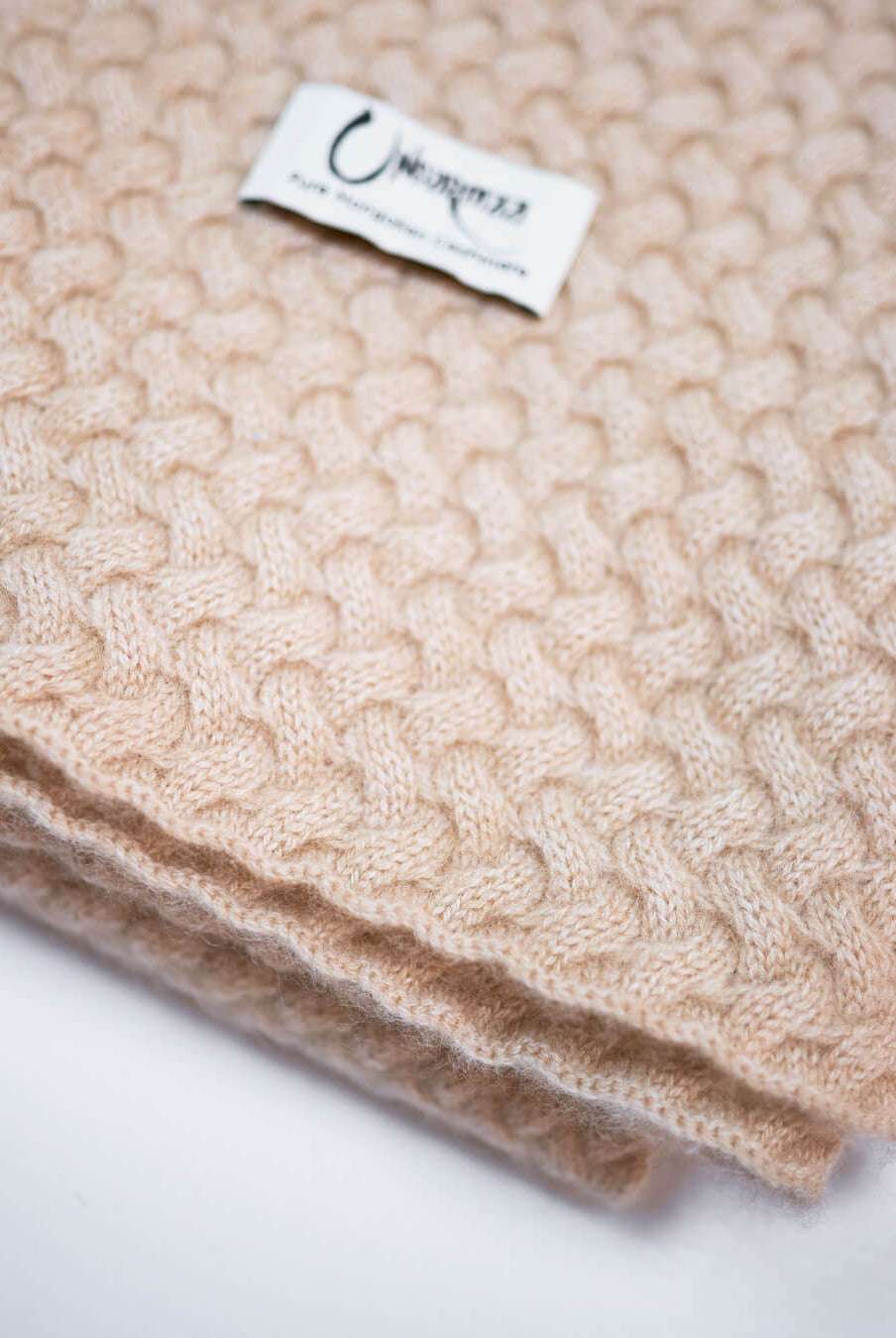 Detalje med logo af strikket plaid i 100% cashmere.