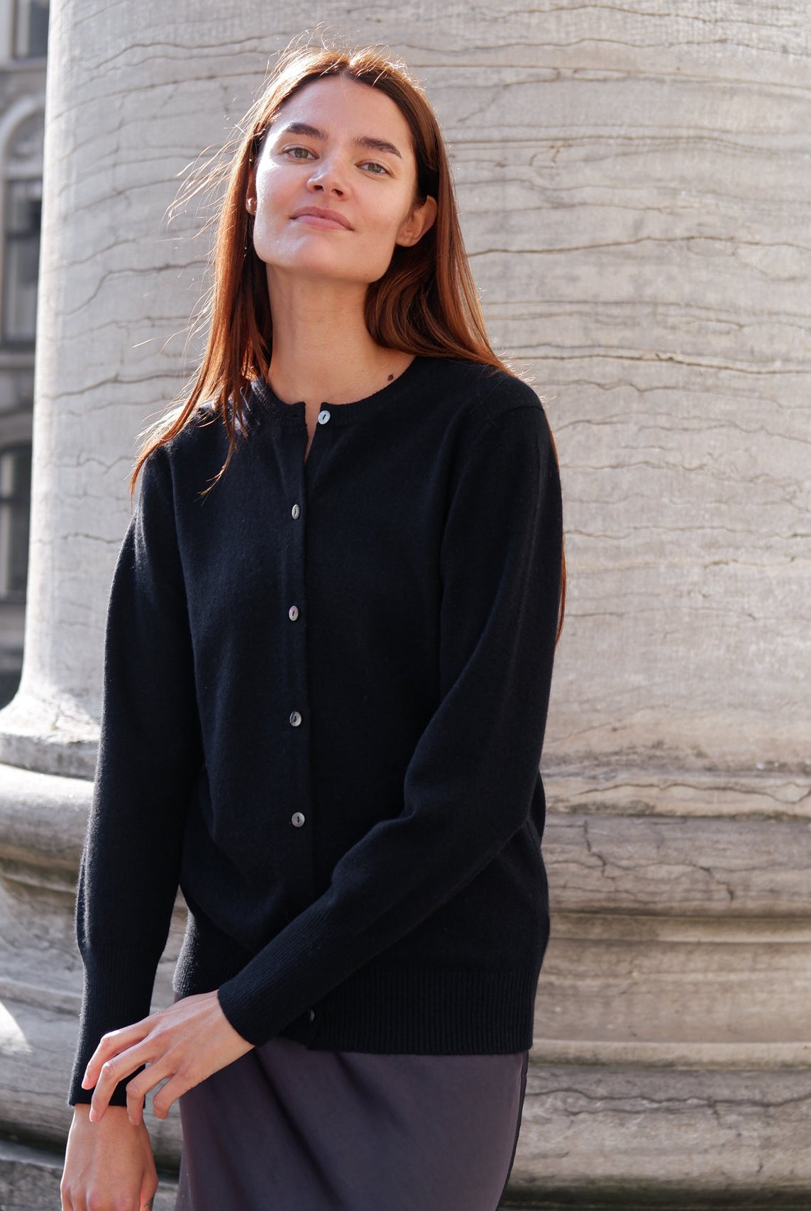 en cashmere cardigan i en sort farve stylet med et skørte