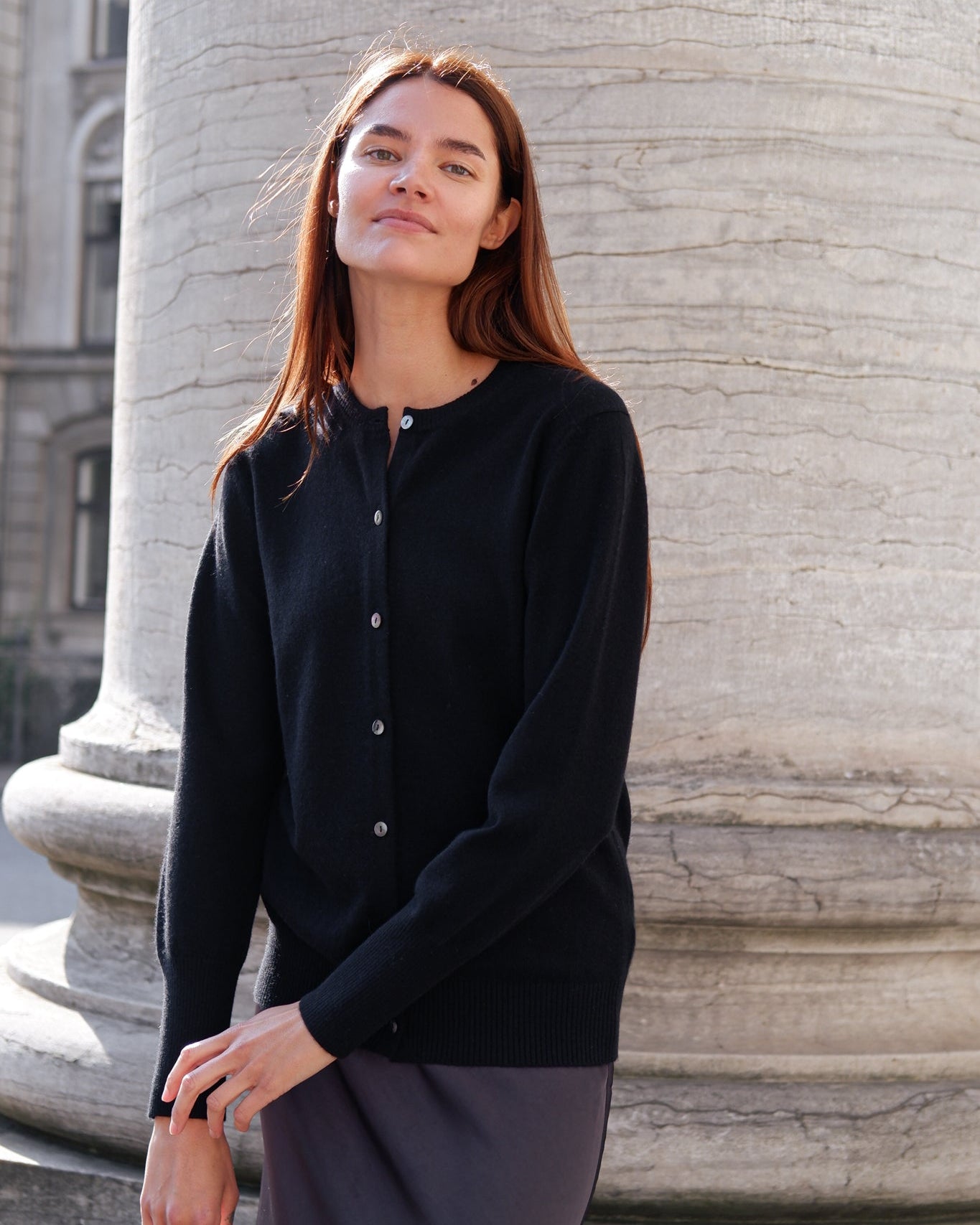 en cashmere cardigan i en sort farve stylet med et skørte