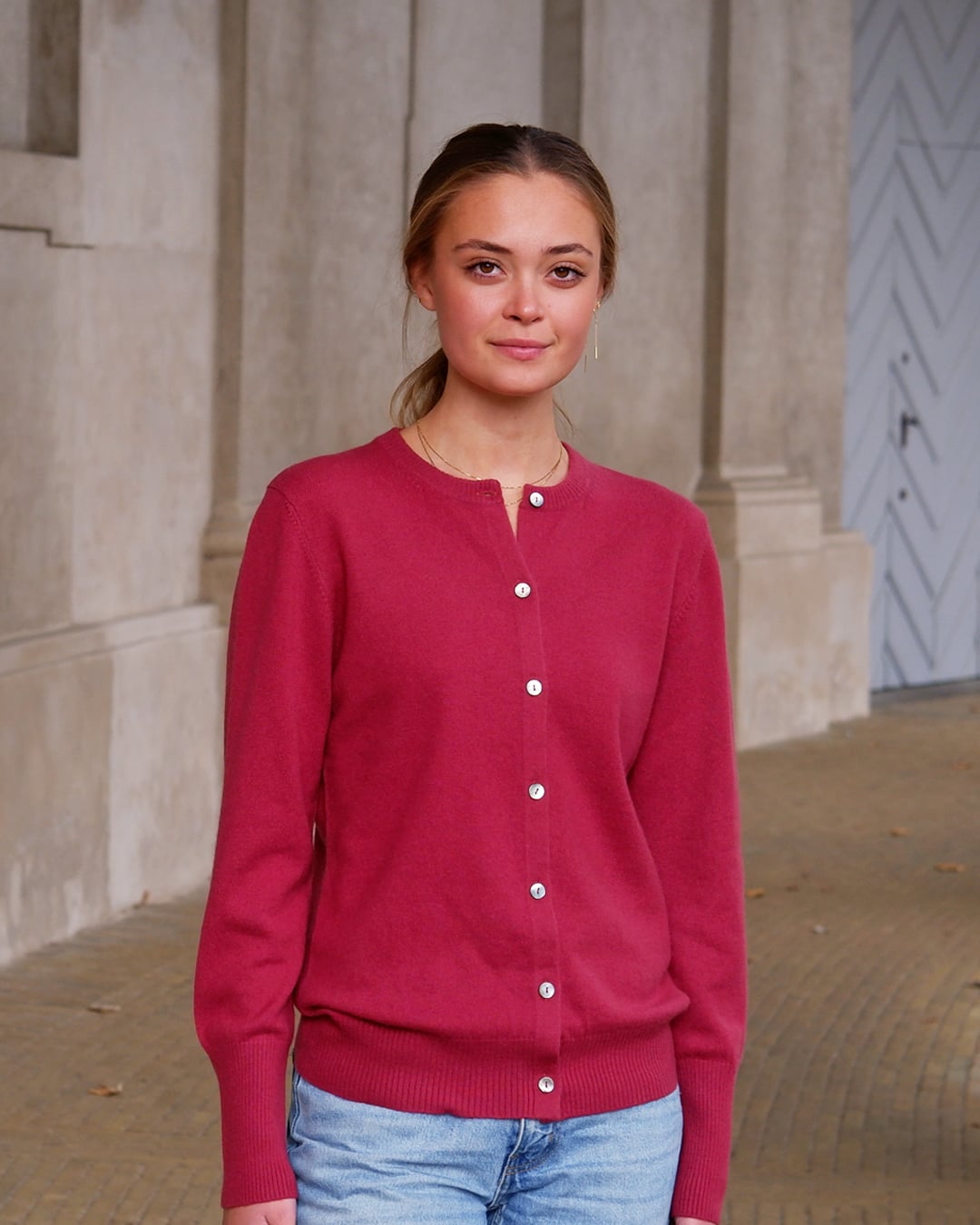 Kvinde iført Alma cardigan i Raspberry, set forfra.