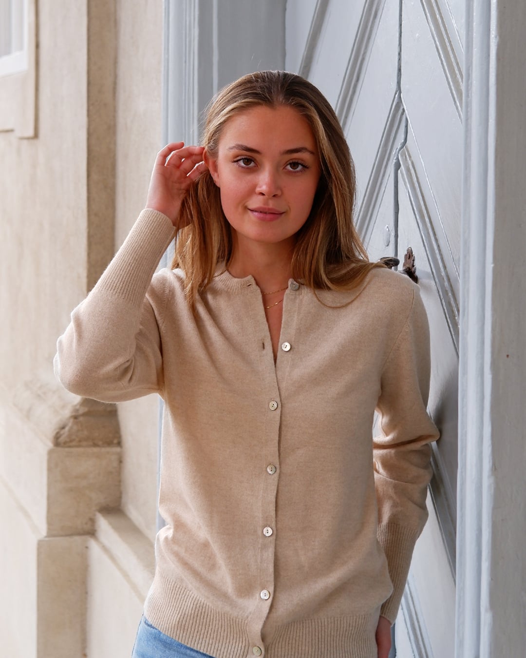 Kvinde iført Alma cardigan i Natural sand, set forfra.