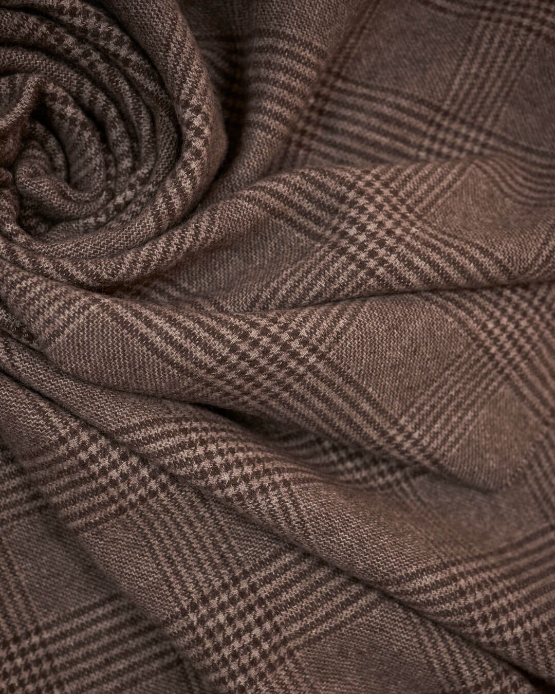 Detaljebillede af yakuld plaid i brunternet mønster, vist foldet i bløde lag