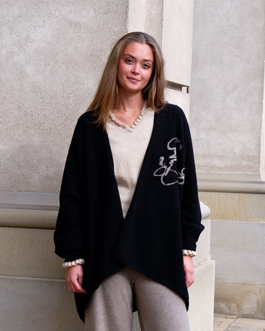 Kvinde iført sort cashmere-kappe Anu, åben model uden lukning.