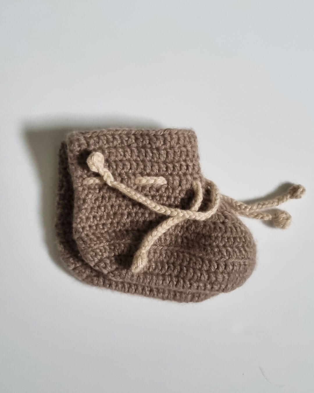Saruul cashmere footies i Natural Taupe – bløde, varme og naturlige.