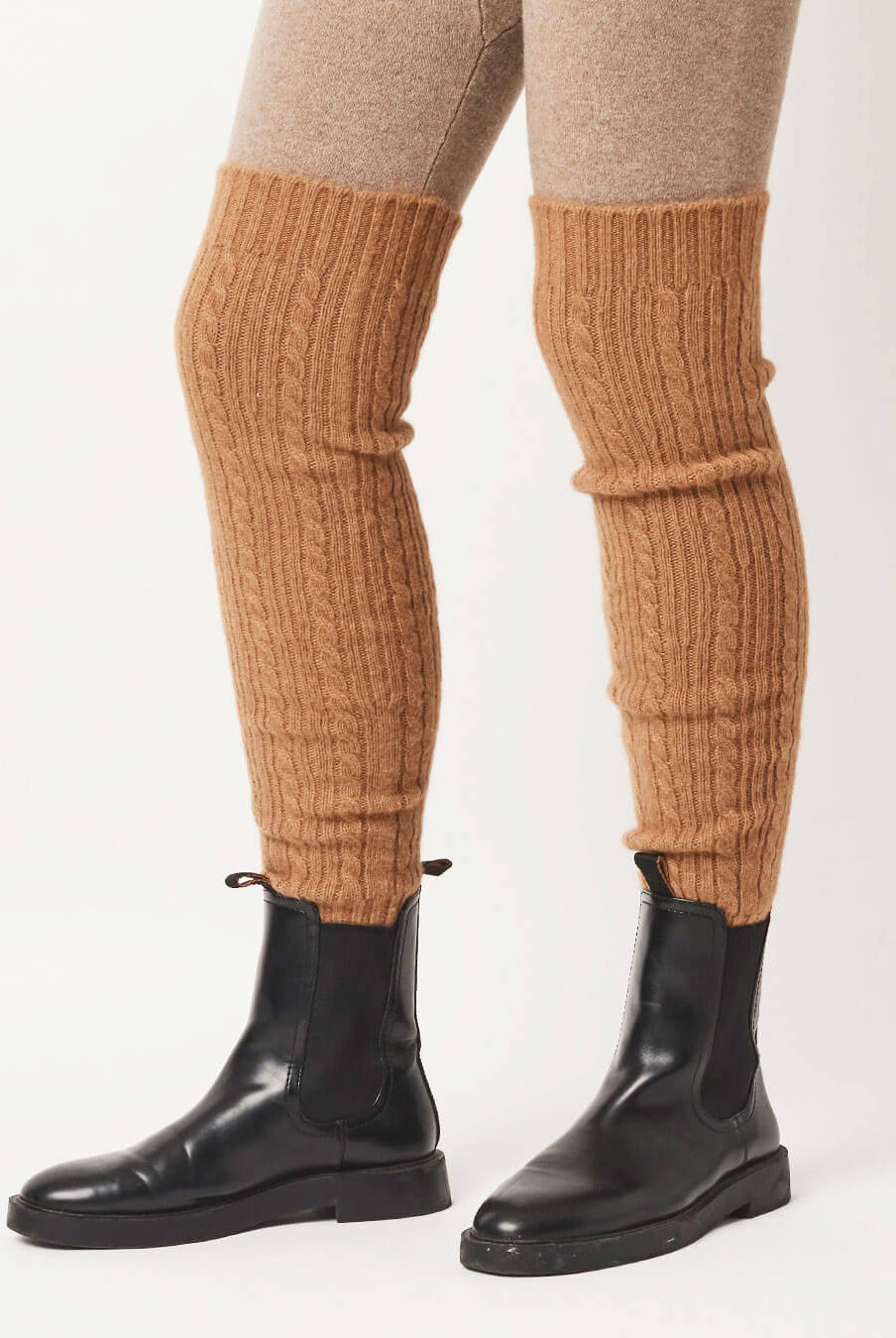 Ribstrikkede kamelulds benvarmere stylet over leggings og støvler.