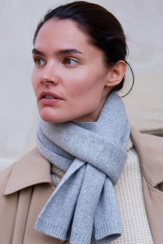 Klassisk kashmirscarf i ljusgrått, som elegant kombinerar lyx och femininitet. Ett tidlöst val för alla garderober.