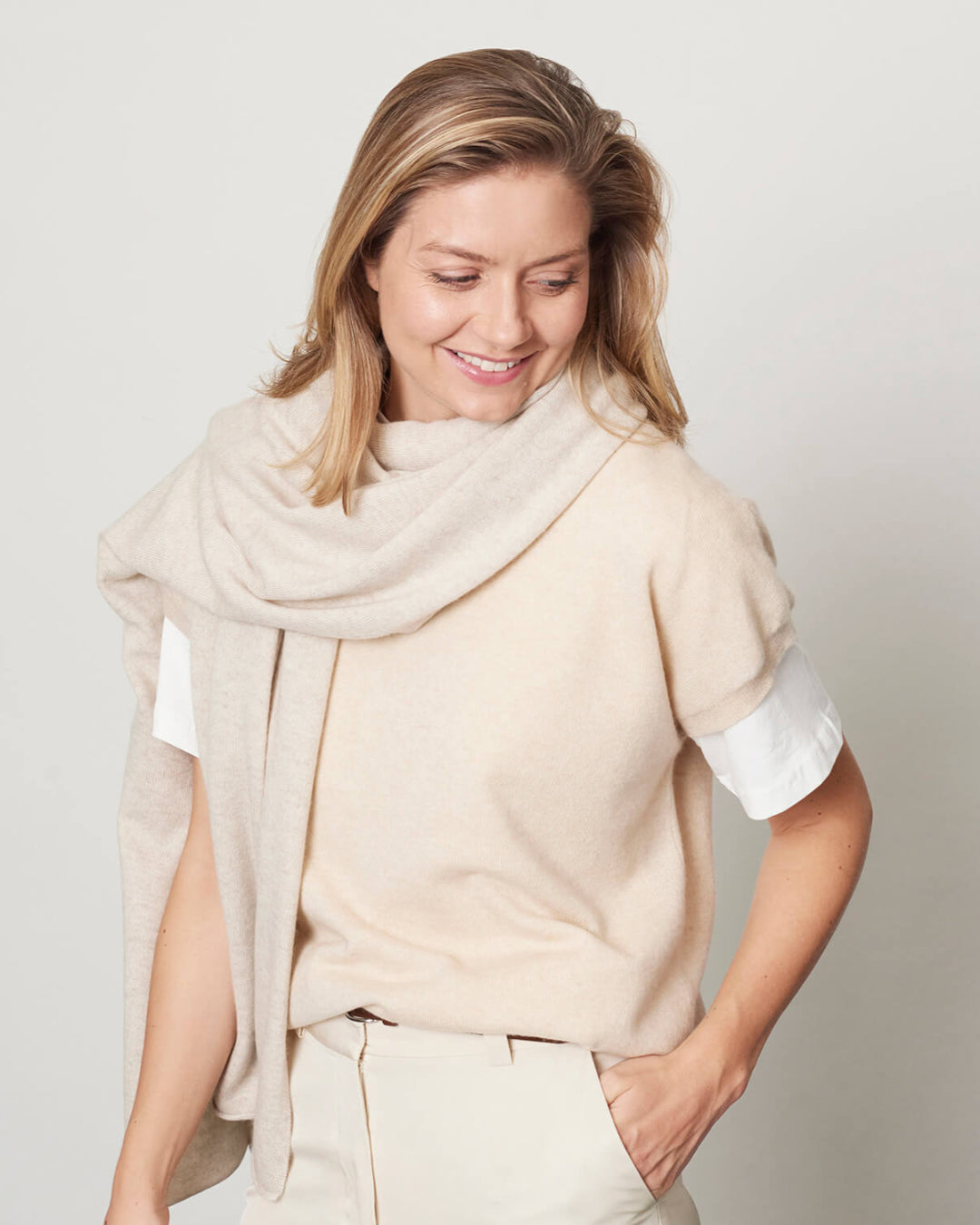 Model med det store naturfarvede cashmere tørklæde i lys gråbeige.