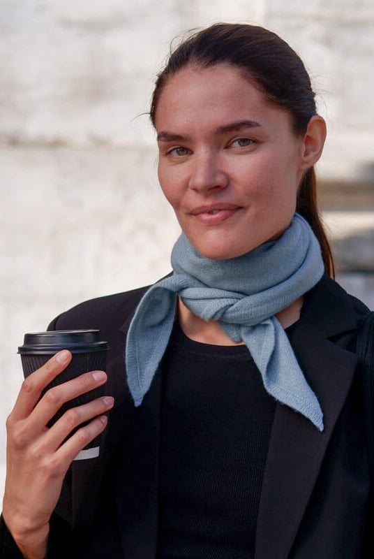 Kvinde med trekantet cashmere tørklæde i farven Dusty Blue.
