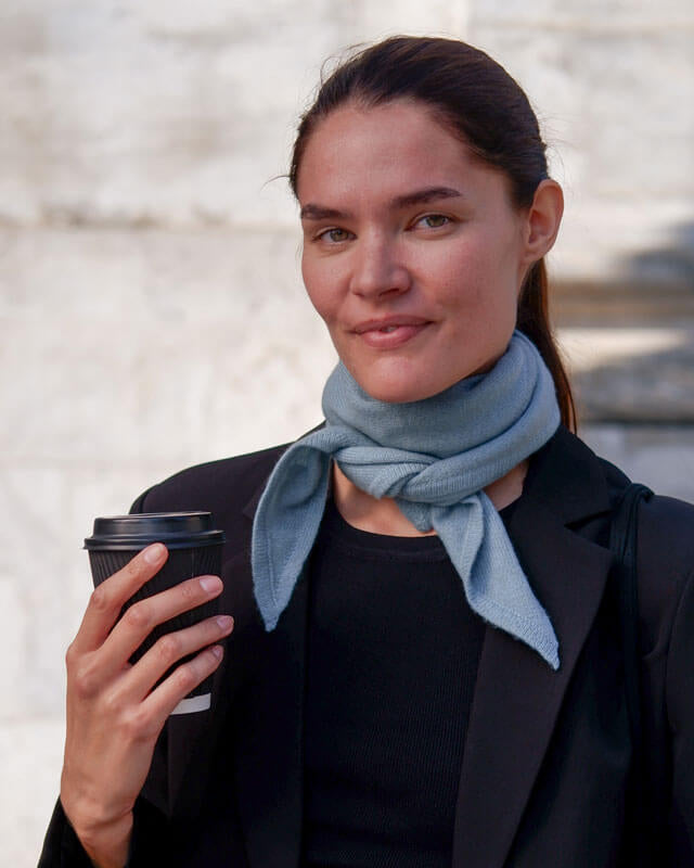 Kvinde med trekantet cashmere tørklæde i farven Dusty Blue.