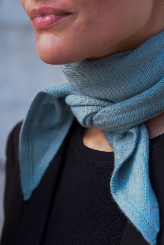 Nærbillede af trekantet cashmere tørklæde i farven Dusty Blue.