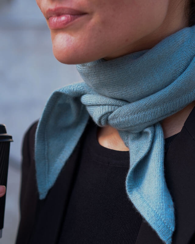 Nærbillede af trekantet cashmere tørklæde i farven Dusty Blue.