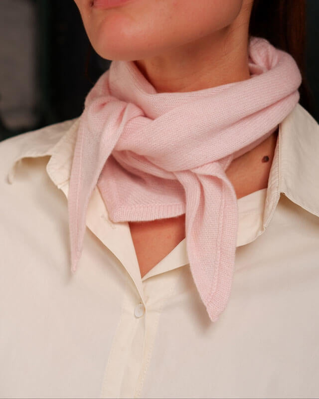 Nærbillede af blush pink cashmere tørklæde med diskret kant.