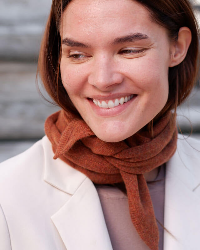 Kvinde med trekantet cashmere tørklæde i farven Fall Brown.