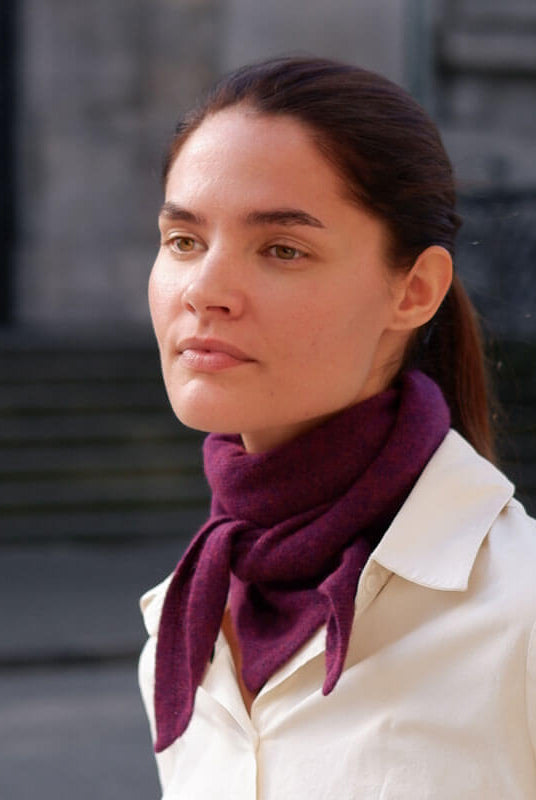 Kvinde med trekantet cashmere tørklæde i farven Grape Purple.