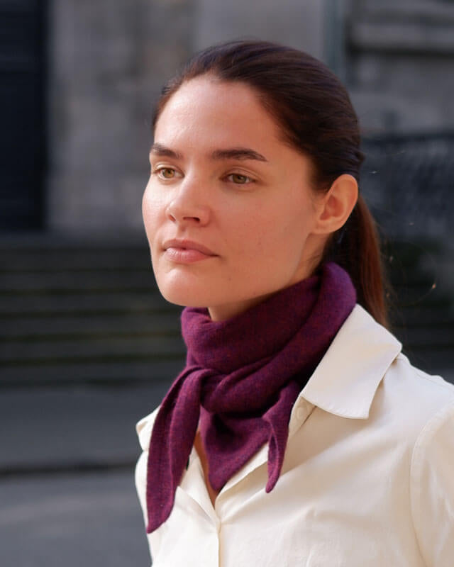 Kvinde med trekantet cashmere tørklæde i farven Grape Purple.