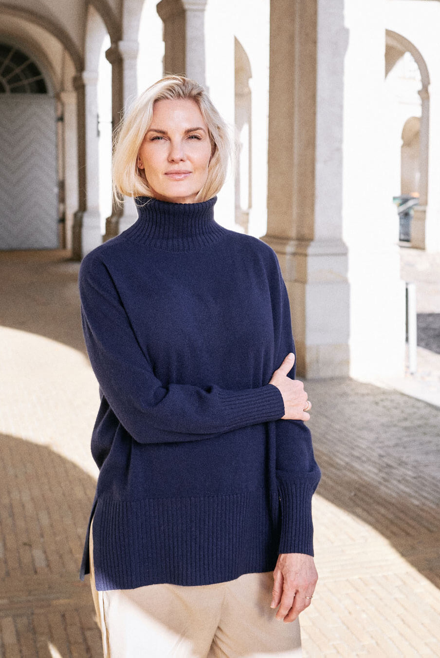 Model iført klassisk cashmere sweater med sadelskuldre og løs pasform i dark navy
