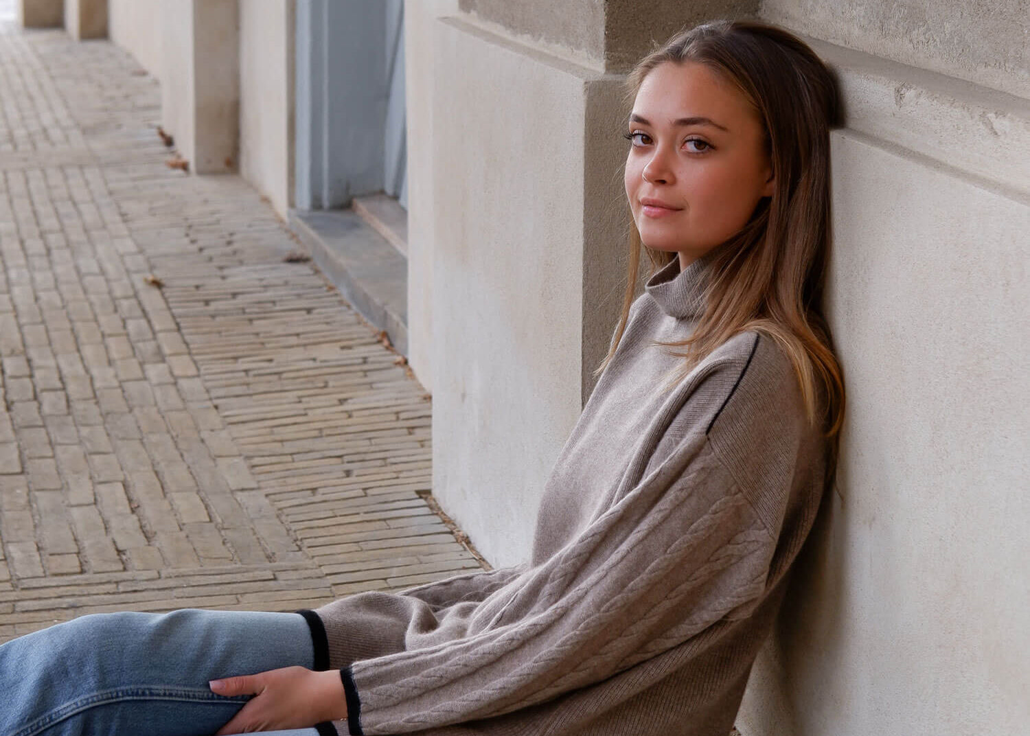 Model iført cashmere mørk gråbeige rullekravebluse, viser dens elegante pasform.