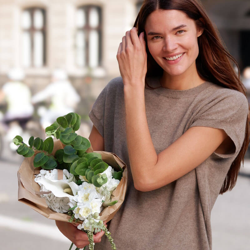 Cashmere vest i farven moss brown med buket blomster, båret af model