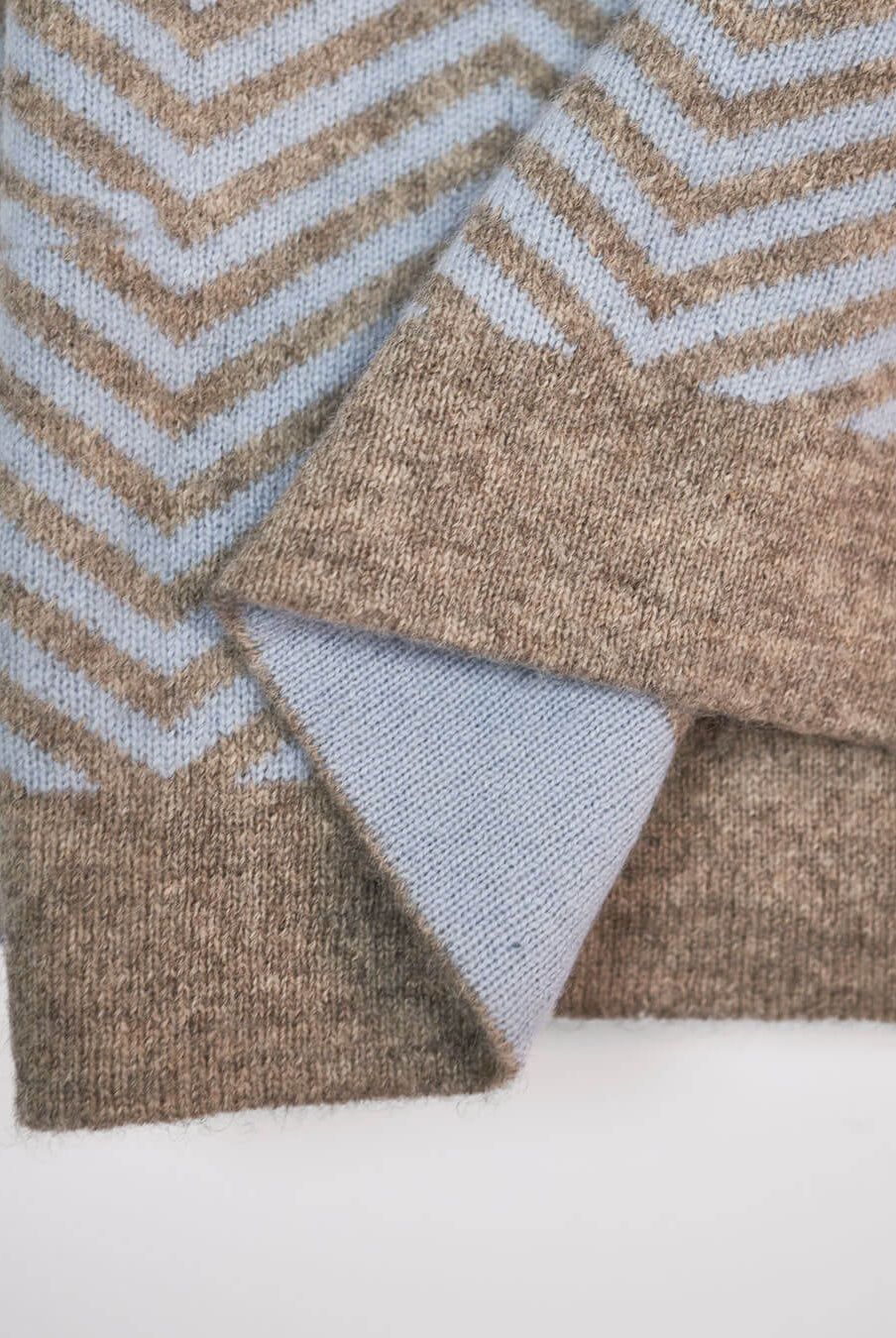 Detalje af plaid i cashmere og yakuld, hvor man ser den platingrå yakuld kant og ice blue cashmere på den modsatte side.