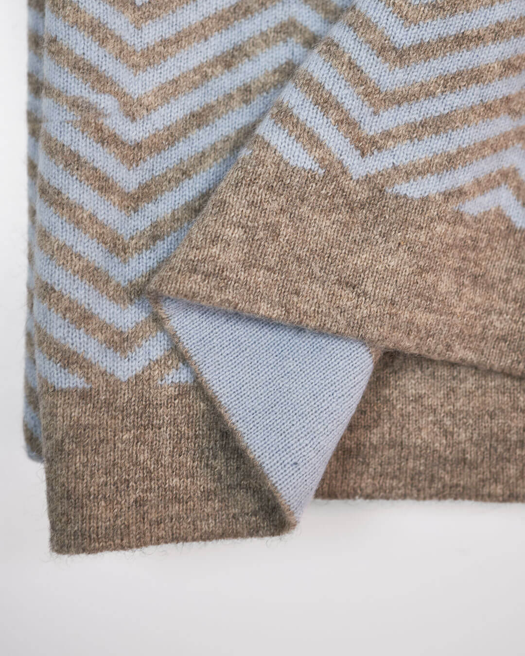 Detalje af plaid i cashmere og yakuld, hvor man ser den platingrå yakuld kant og ice blue cashmere på den modsatte side.