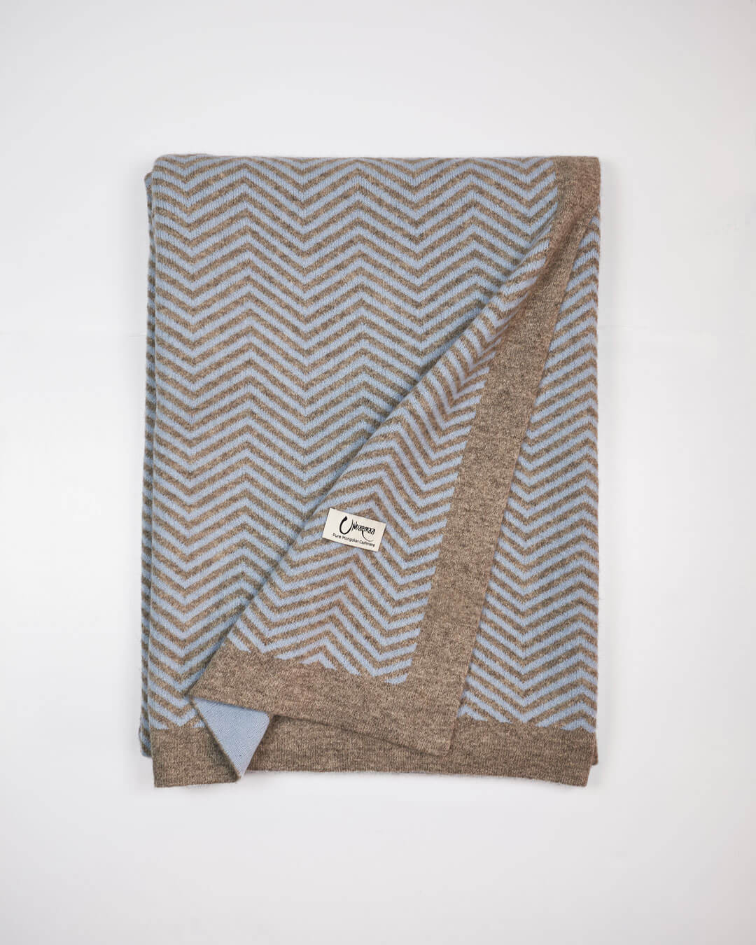 Plaid i cashmere og yakuld med Undarmaa-logo, let foldet i sildemønstret design.