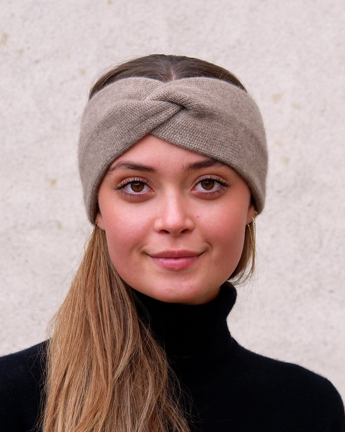 Model iført cashmere pandebånd i Natural taupe set forfra.