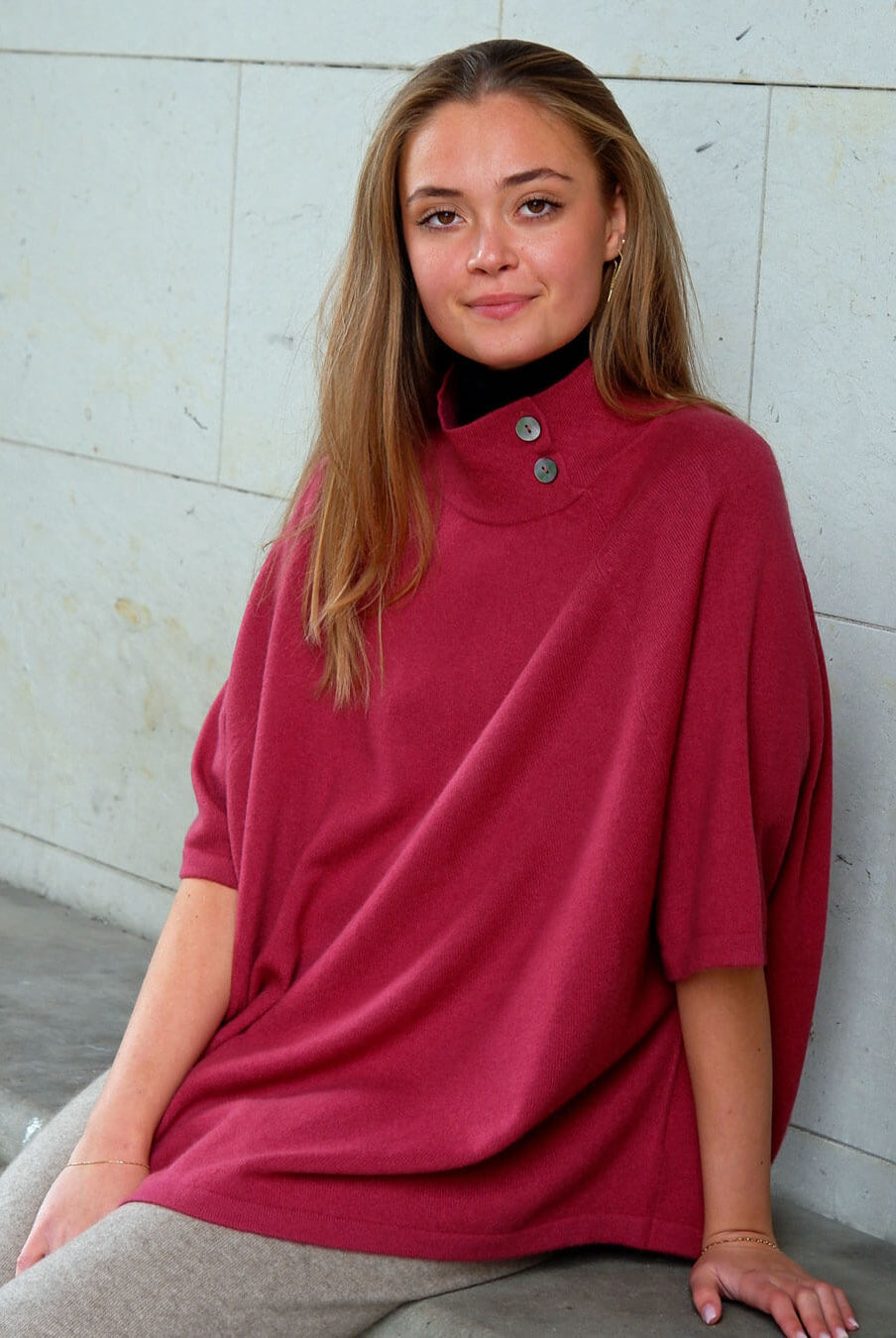 Cashmere poncho i pinot red – varm, blød og klassisk med diskrete knapper i halsen.
