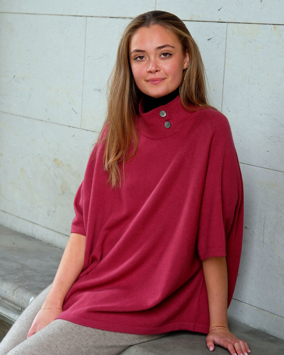 Cashmere poncho i pinot red – varm, blød og klassisk med diskrete knapper i halsen.