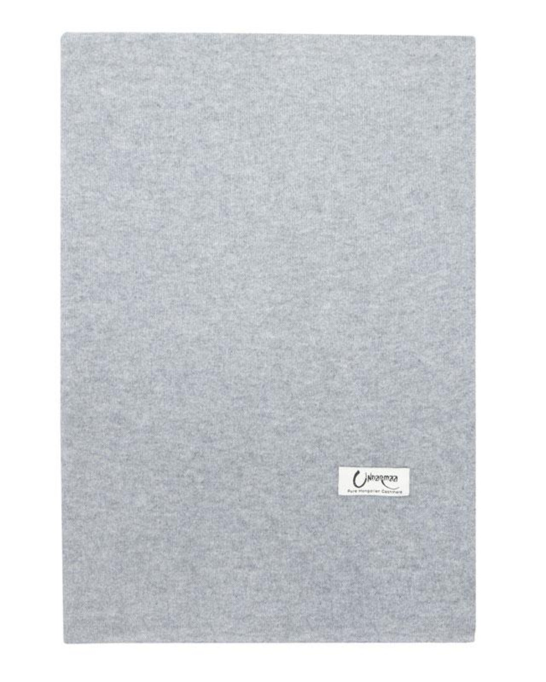 Det store cashmere tørklæde i lys grå ligger fladt og foldet.