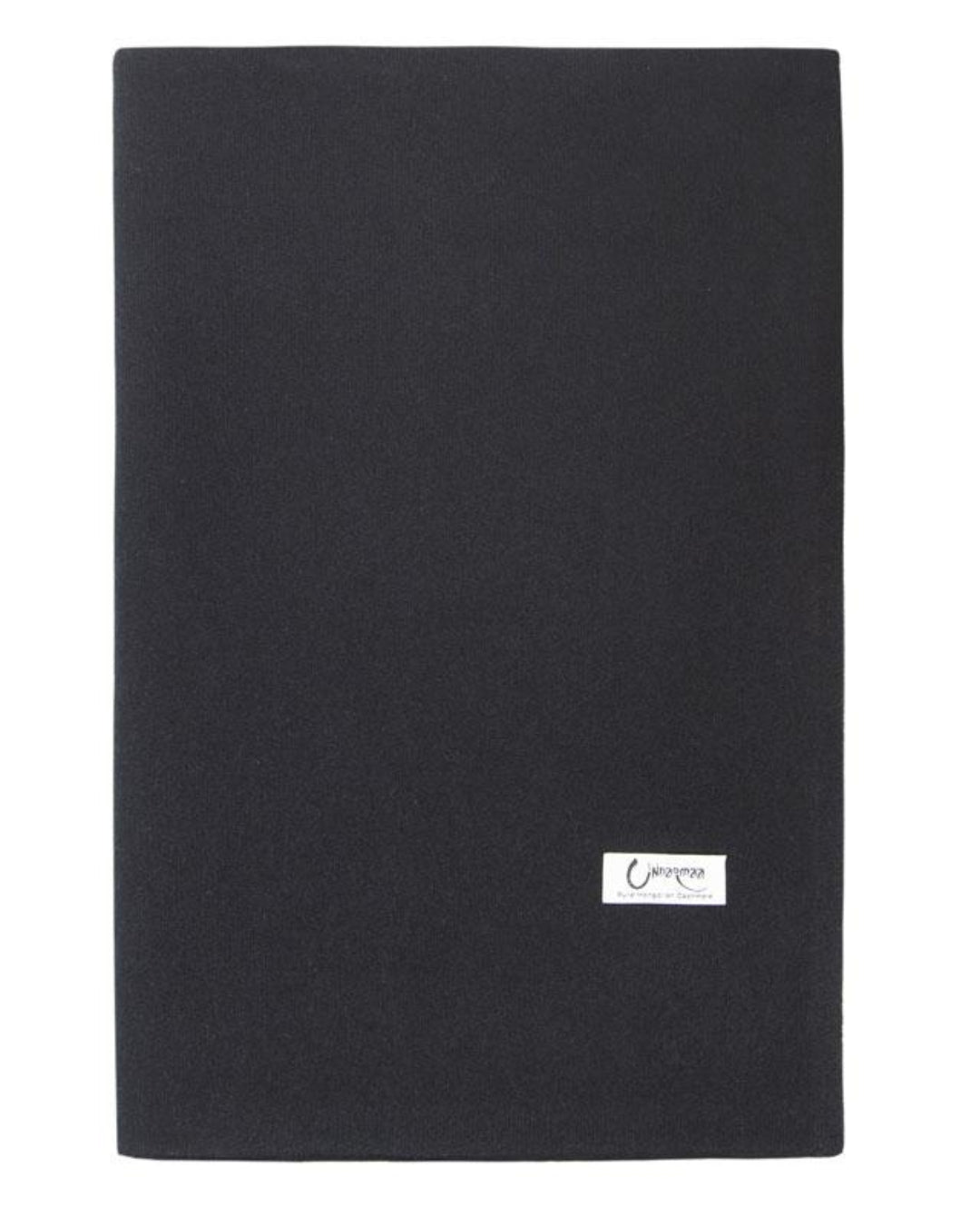 Det store cashmere tørklæde i sort ligger fladt og foldet.