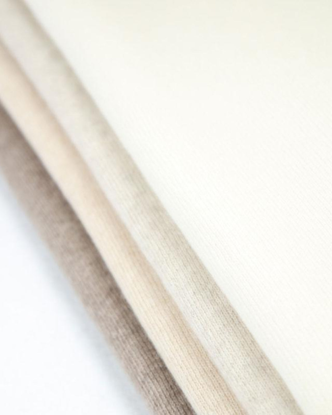 Her ses det store cashmere tørklæde i 4 naturfarver, hvid, lys gråbeige, lys beige og mørk gråbeige.