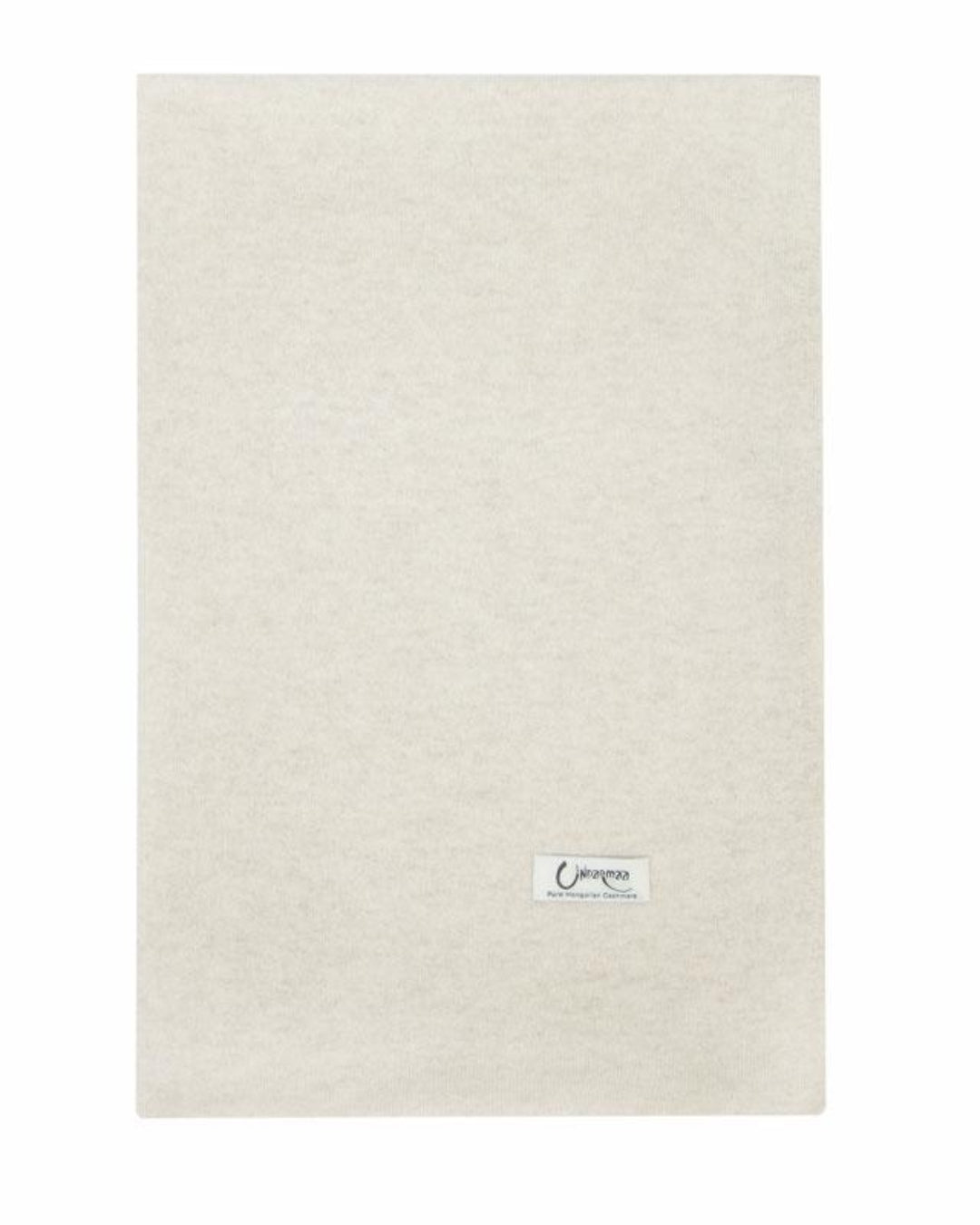 Det store naturfarvede cashmere tørklæde i lys gråbeige ligger fladt.