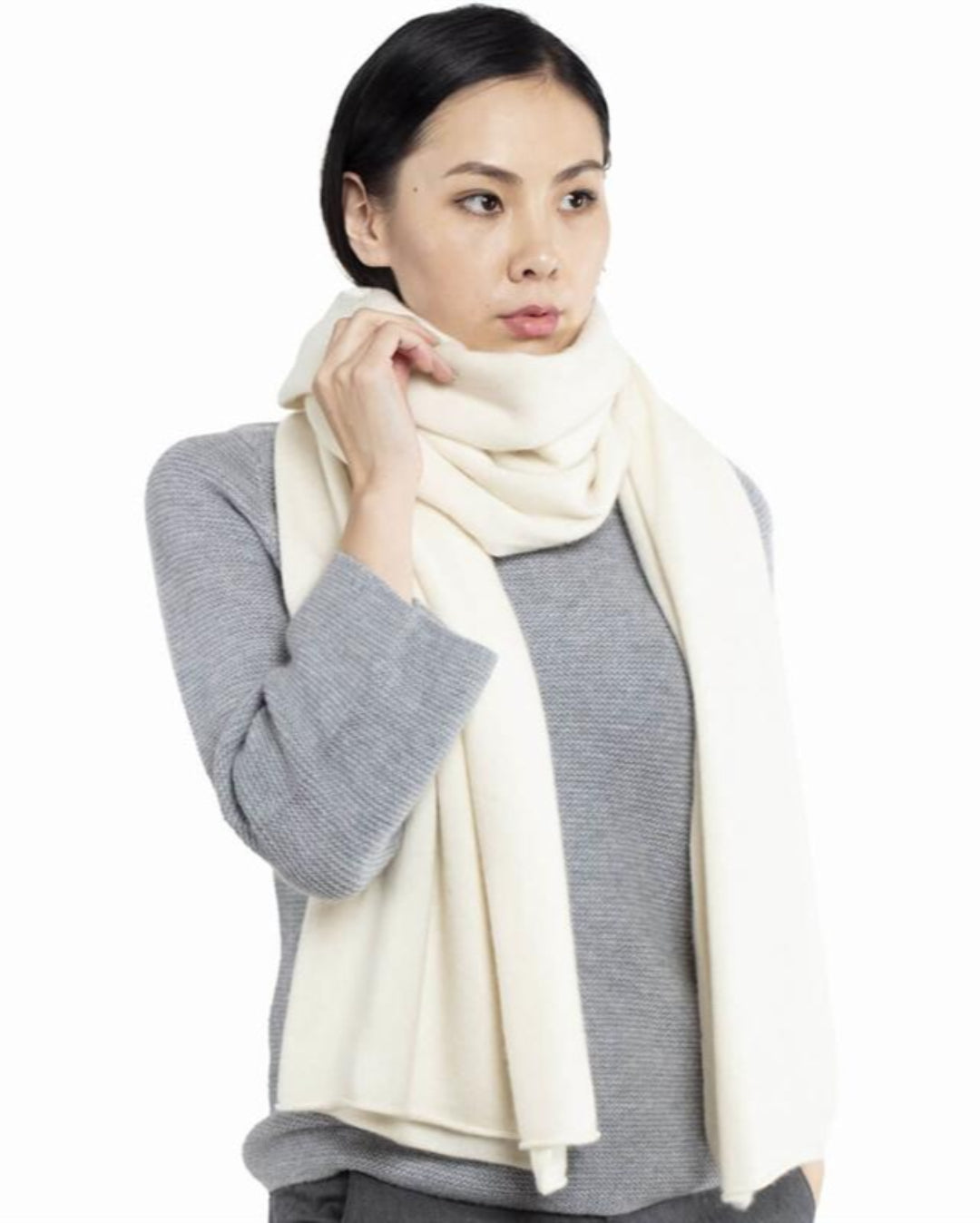 Model med det store naturfarvede cashmere tørklæde i hvid svøbt om halsen.