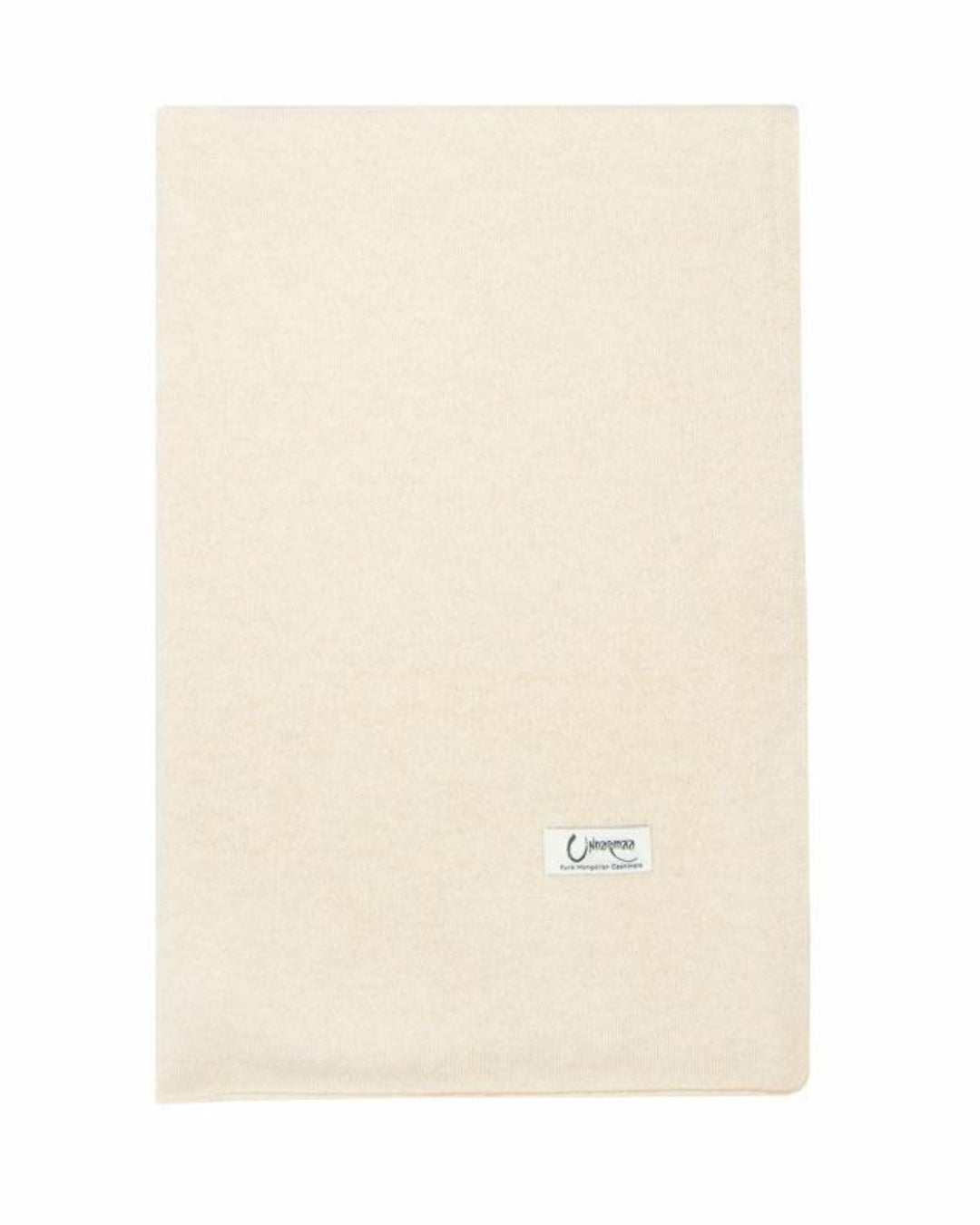 Det store naturfarvede cashmere tørklæde i lys beige ligger fladt.