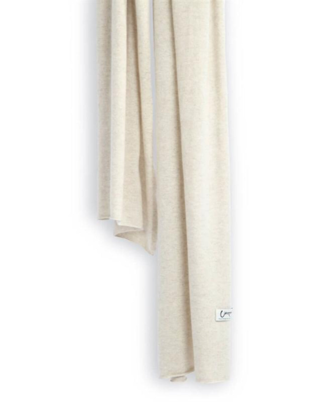 Det store cashmere tørklæde, her i naturfarvet lys gråbeige hænger løst ned.