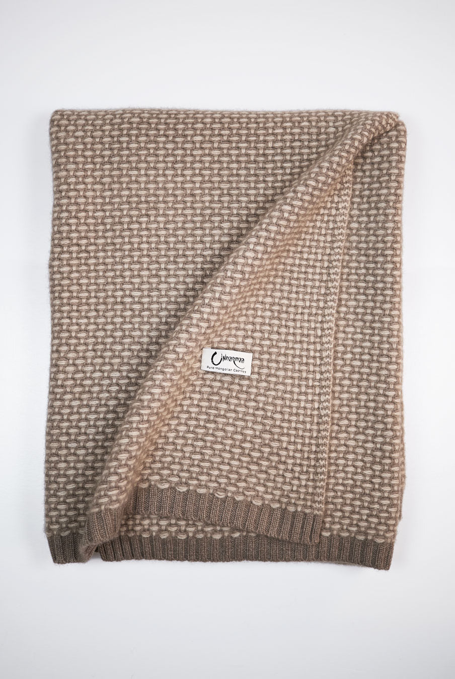 Taiga cashmere plaid i farverne natural taupe og natural sand, foldet med synligt mønster og Undarmaa-label.