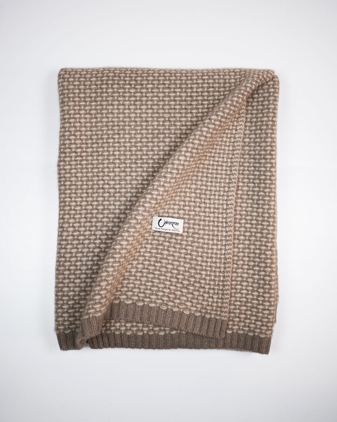 Taiga cashmere plaid i farverne natural taupe og natural sand, foldet med synligt mønster og Undarmaa-label.