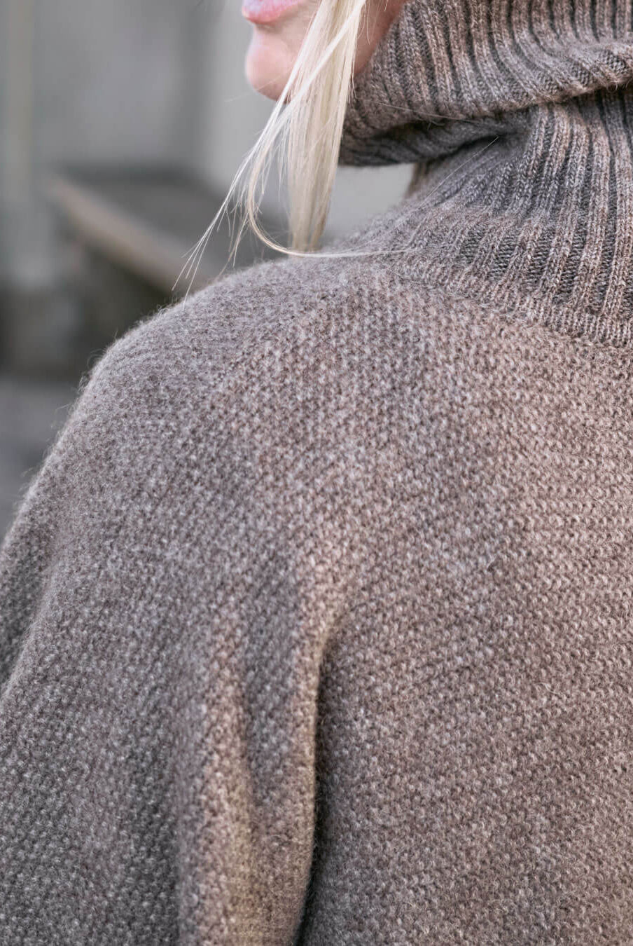 Detalje af skulder på Tara yakuld poncho med rullekrave i Yak Dark Grey.