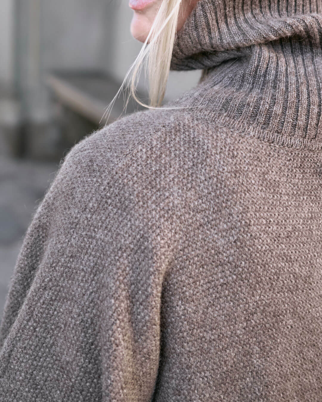 Detalje af skulder på Tara yakuld poncho med rullekrave i Yak Dark Grey.
