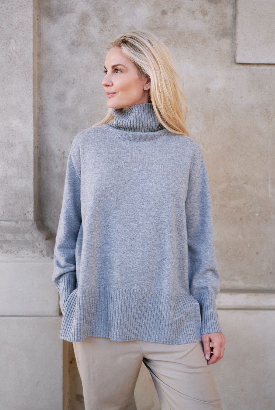 Model iført klassisk cashmere sweater med sadelskuldre og løs pasform i soft grey