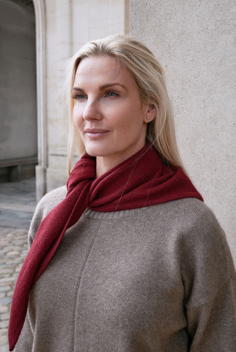 Model med trekantet cashmere tørklæde i farven Bordeaux.