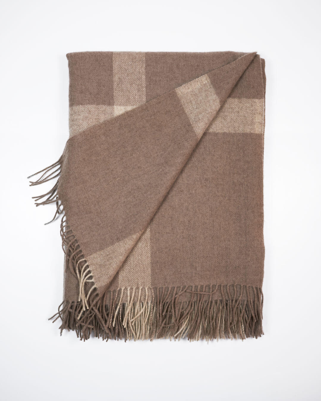 Vævet plaid i 100% yakuld med naturlige tern i beige og brun let foldet så man ser bagsiden.