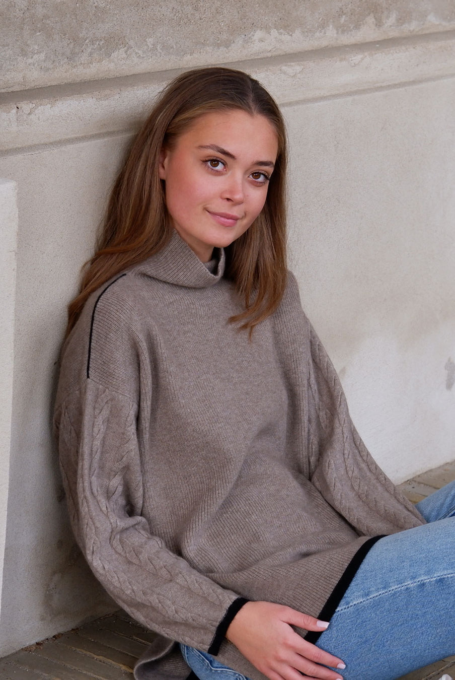 Model iført Tuya cashmere mørk gråbeige rullekravebluse med mønster.