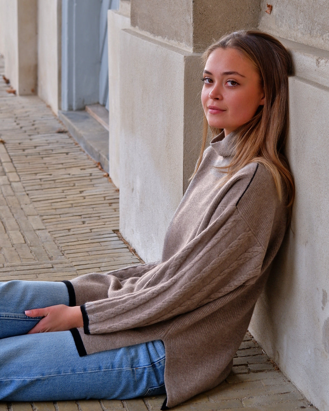 Tuya rullekrave i natural taupe, model i afslappet siddende positur