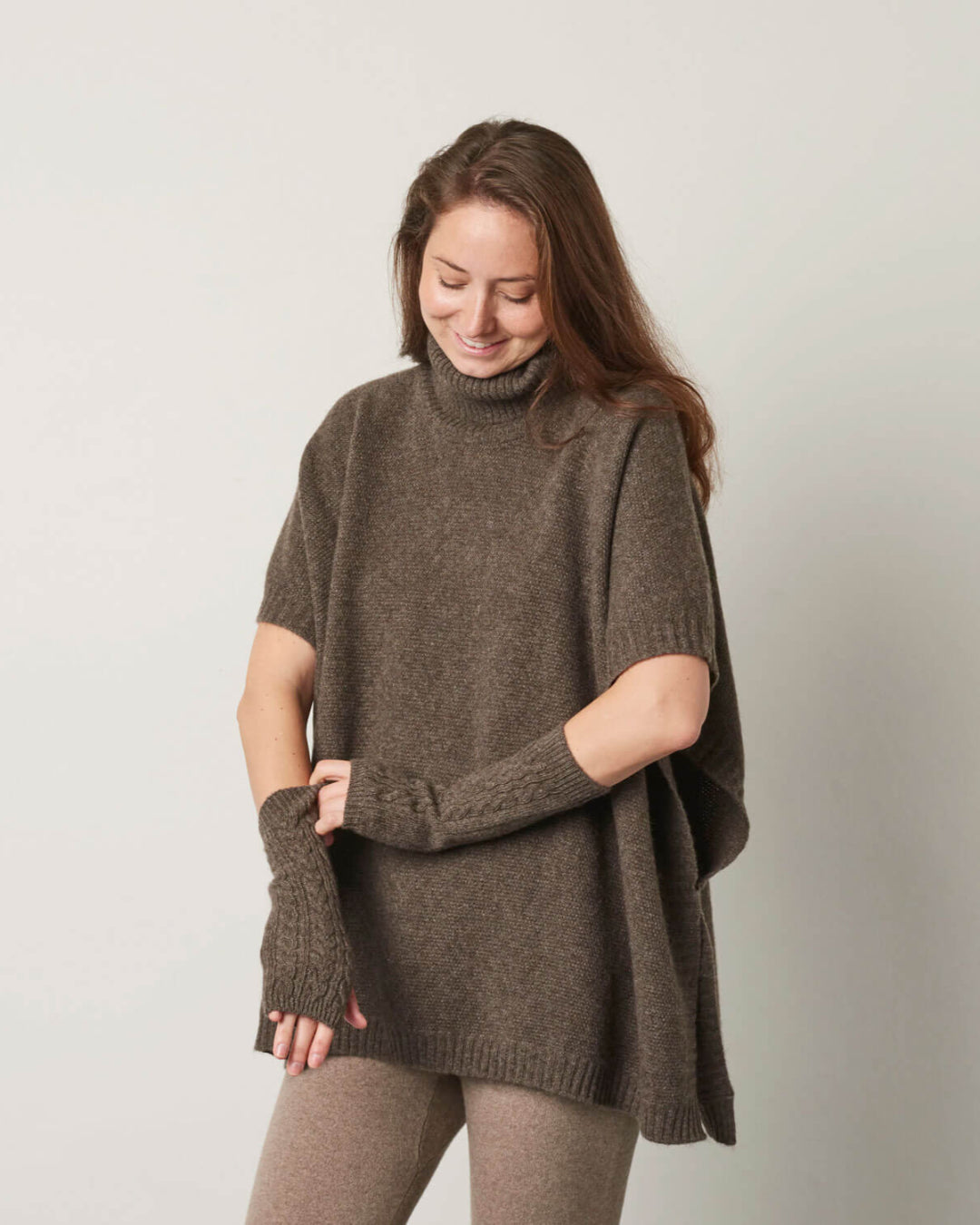 Håndledsvarmere i gråbrun yakuld båret af en model, der viser deres længde og mønster.