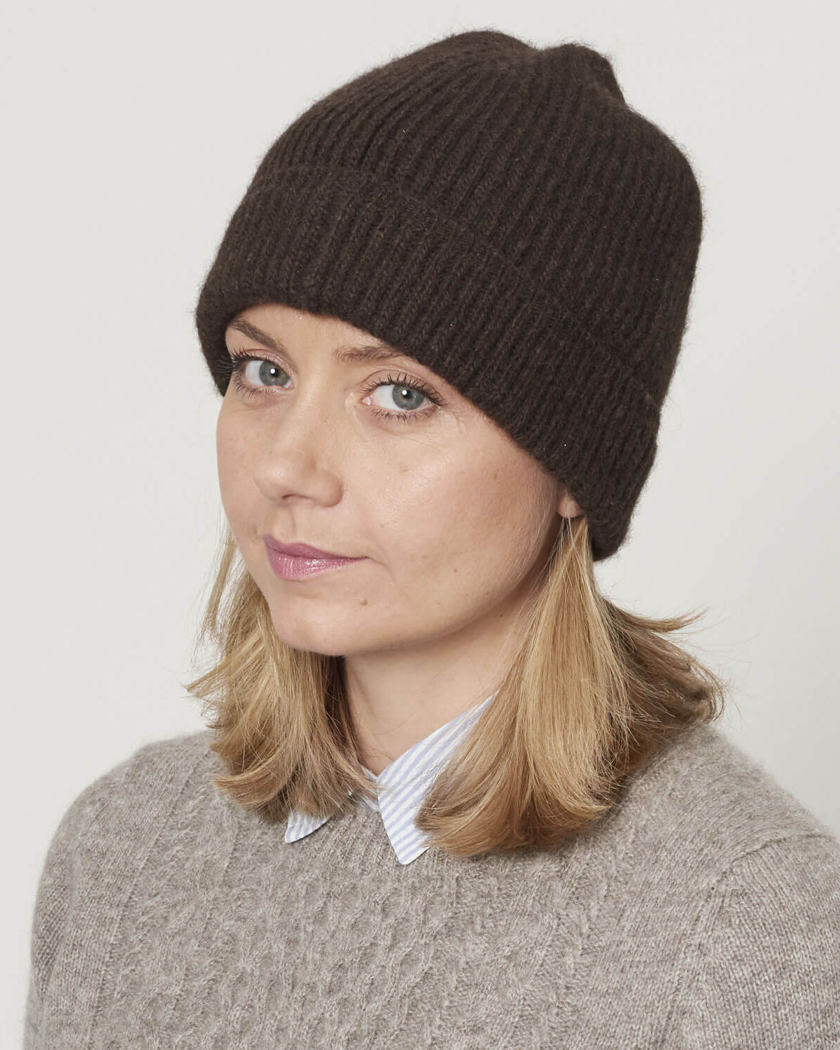Model med strikket yakuld hue i mørk brun naturfarve.