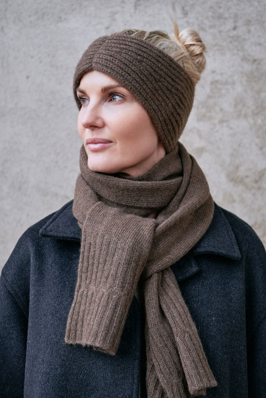 Model i mørk frakke med yak pandebånd i Yak Mocha, klassisk vinterlook.